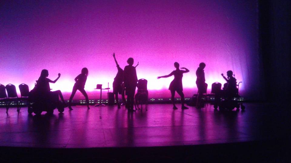 Seven dancing human silhouettes and one dog silhouette pose against a bright violet background.