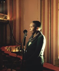 Photo of Audrey Mitchell speaking into a microphone.