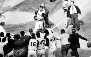 Photo of Bill Mazeroski being greeted by teammates as he arrives at home plate.