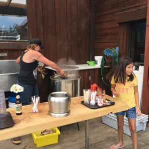 Photo of woman dropping live crab into boiling water.